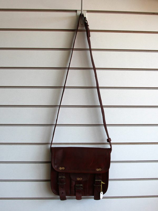 Leather purse with buckles hanging on slatwall